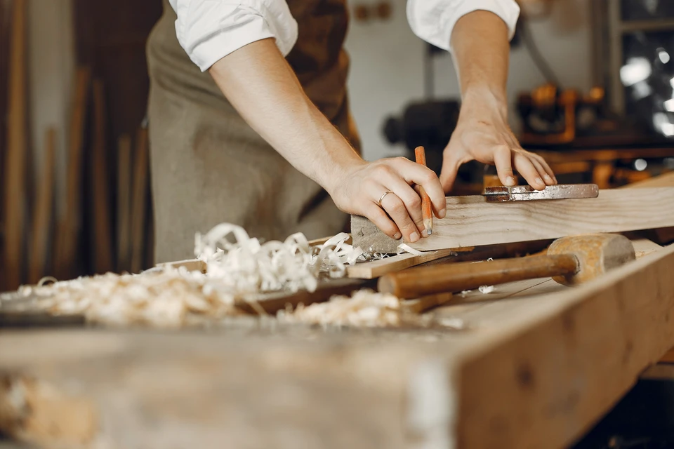 Atelier de menuiserie avec artisan travaillant le bois sur établi