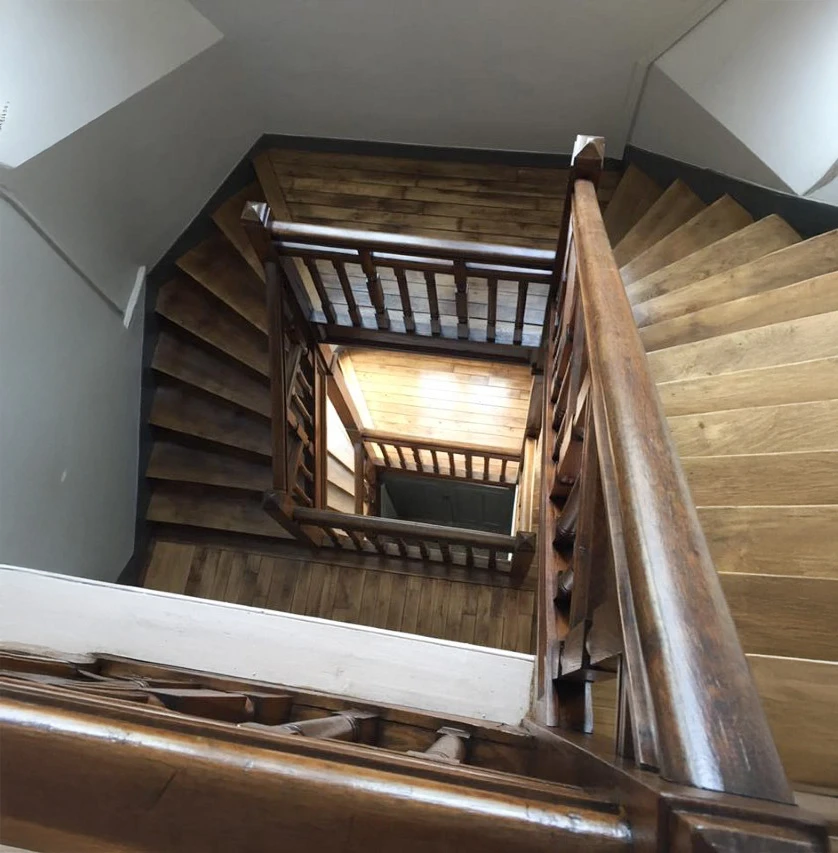 Intérieur résidentiel avec escalier en bois massif et sol entièrement rénové
